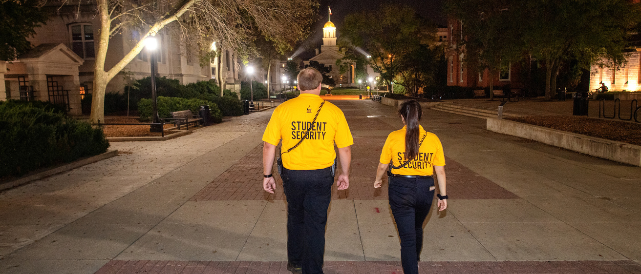 Two student security officers walk down T. Anne Cleary Walkway.